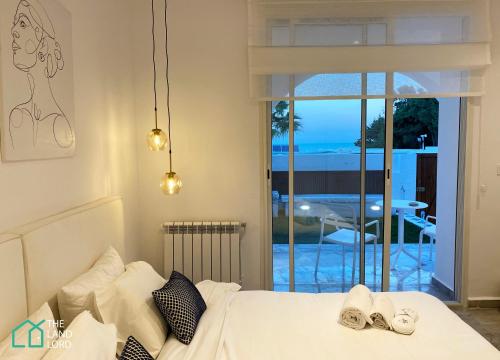 a bedroom with a bed and a view of the ocean at New 1 bd with garden and sea side at Marsa Cornich in Douar el Hafey