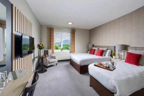 a hotel room with two beds and a flat screen tv at Castlerosse Park Resort in Killarney