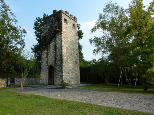 an old brick tower in a park with trees at B&B La Grola in San Martino Buon Albergo