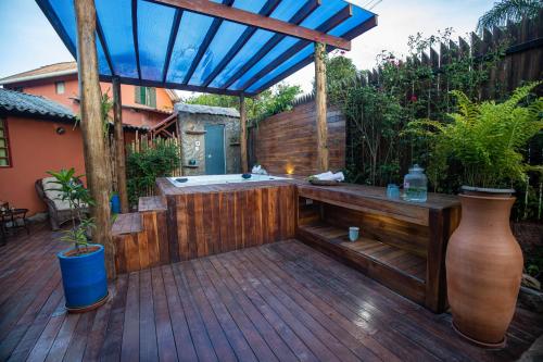 a hot tub on a wooden deck with a blue umbrella at Buddy's Hostel & Pousada Alto Paraiso in Alto Paraíso de Goiás