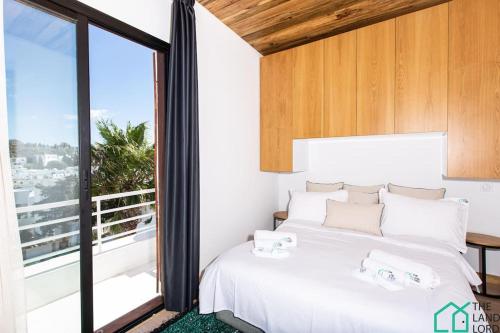 - une chambre avec un lit blanc et une grande fenêtre dans l'établissement Panoramic View Enjoy a Jacuzzi in Sidi Bou Said, à Dar Salah Bey