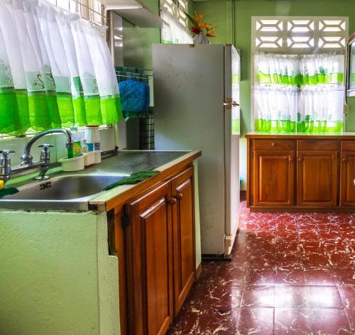 a kitchen with a sink and a refrigerator at Cholson Chalets in Charlotteville
