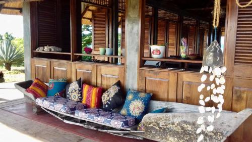 a couch with colorful pillows sitting on a porch at Villa Moringa lodge 