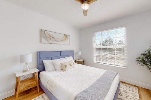 Un dormitorio con una cama azul y una ventana en Beach Sunflower, Unit #516, en Fort Myers