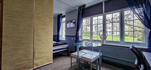 a room with a glass table in front of a window at 206mm Highgate Apartment in London