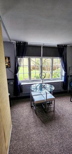 a room with a glass table in front of windows at 206mm Highgate Apartment in London