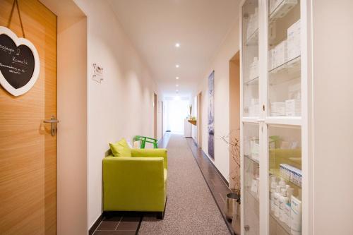 a hallway with a green chair in a room at Brauers Landarthotel GmbH in Daun