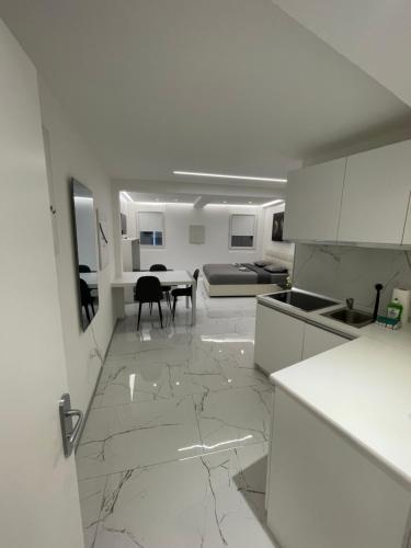 a white kitchen with marble floors and a table at TALEDA Apartments - Modern Apartments & Self Checkin in the Old Town in Lugano