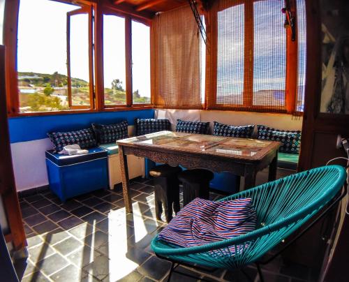 a table and chairs in a room with windows at USHA Guest House in Chefchaouene