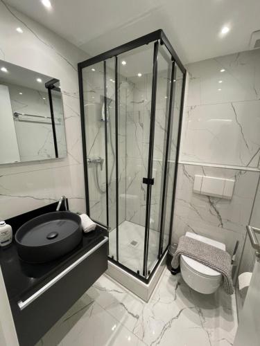 a bathroom with a glass shower and a toilet at TALEDA Apartments - Modern Apartments & Self Checkin in the Old Town in Lugano
