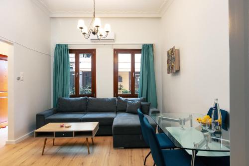 a living room with a blue couch and a glass table at Centro Storico in Chania Town