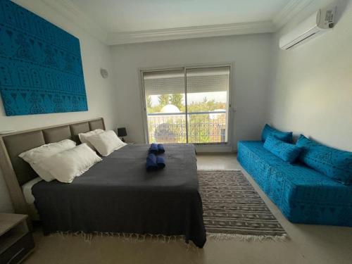 um quarto com uma cama e um sofá azul em Villa des Oliviers Hammamet B&B em Hammamet