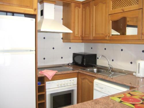 a kitchen with a sink and a stove top oven at Playa Marina Phase I in Cabo Roig