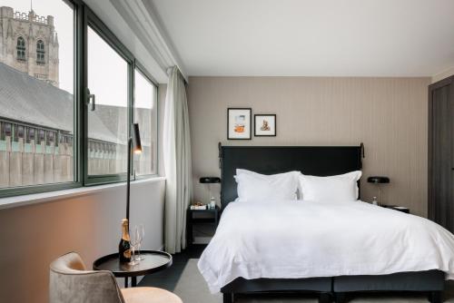a hotel room with a bed and a chair at Pillows City Hotel Brussels Centre in Brussels