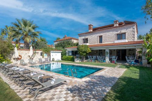 a villa with a swimming pool in front of a house at Alacati Koclu Konagi Hotel in Alacati