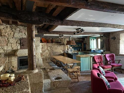 een keuken en een woonkamer met een tafel en stoelen bij Casa do Tio Plácido in Valezim