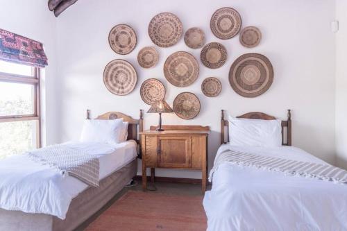 - 2 lits dans une chambre avec des plaques murales dans l'établissement Des'lgodini Lodge - PRM078, à Bela-Bela