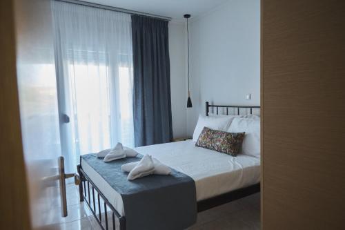 um quarto com uma cama e uma grande janela em BUTTERFLY SUITES by STELIOS em Keramoti