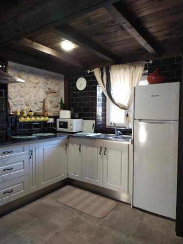 a kitchen with white cabinets and a white refrigerator at Vivienda Vacacional La Yaya in Ortiguero