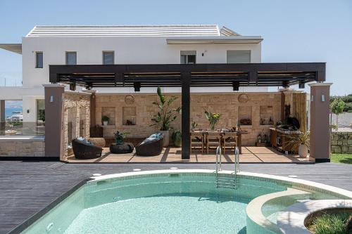a swimming pool in front of a house at Villa Peacock with Spa Facilities in Daratso