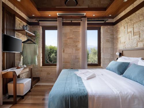 a bedroom with a bed and a desk and windows at Villa Peacock with Spa Facilities in Daratso