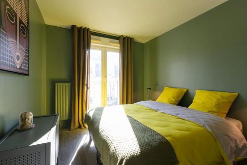una camera verde con un letto e una finestra di La Citadelle a Nancy