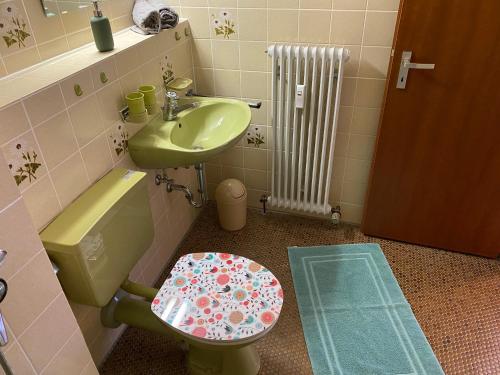 a bathroom with a green toilet and a sink at Auszeit in Immenstaad am Bodensee