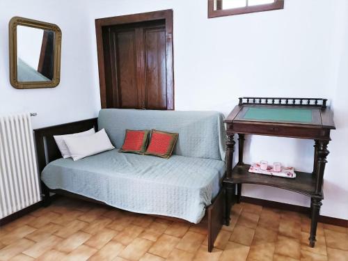 a blue couch with pillows next to a table at Charming Home by Lake with Scenic Trails in Maccagno Inferiore