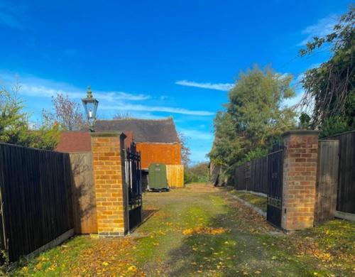 a gate to a house with a fence at The Cart House - Staverton Cheltenham in Cheltenham