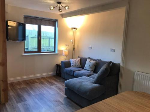 a living room with a couch and a tv at Blacklaines Annexe Birdlip - Pet friendly! in Gloucester