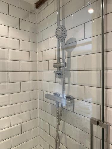 a shower with a shower head in a bathroom at The Nags Head - Room only accommodation in Lyme Regis