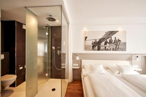 a bedroom with a bed and a glass shower at Der Kleine Hans in Sankt Michaelisdonn