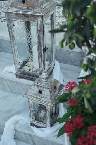 a birdhouse and a mirror on a table with flowers at BUTTERFLY SUITES by STELIOS in Keramotí