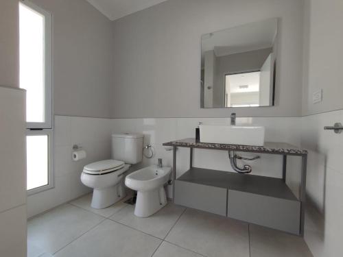 a bathroom with a toilet and a sink and a mirror at Otilia de Ampuero N°7 in Aldea Camarero