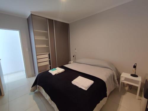 a bedroom with a bed with two towels on it at Otilia de Ampuero N°7 in Aldea Camarero