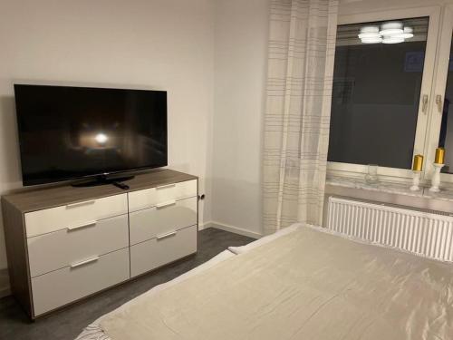 a living room with a flat screen tv on a dresser at B&O Vermietung in Kerken