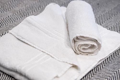 une pile de serviettes blanches assises sur un lit dans l'établissement Stylish Stamford Centre 2 Bedroom Apartment - St Pauls Apartments - B, à Stamford