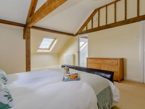 een slaapkamer met een bed met een dienblad met eten erop bij Mulberry Cottage in North Wootton
