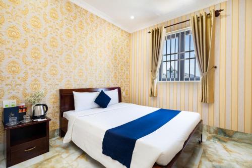 ein Schlafzimmer mit einem großen Bett und einem Fenster in der Unterkunft Joi Hospitality - KP House in Vũng Tàu