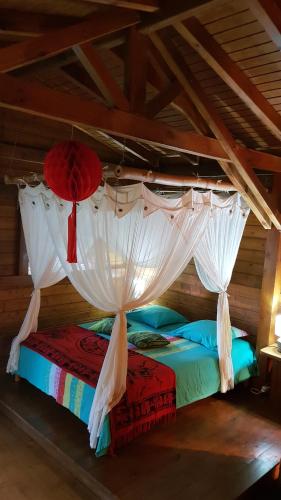 ein Schlafzimmer mit einem Himmelbett in der Unterkunft La Creolina in Sainte-Rose