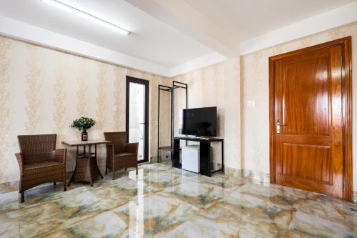 a living room with a wooden door and a table and chairs at Joi Home The Hidden Villa in Vung Tau