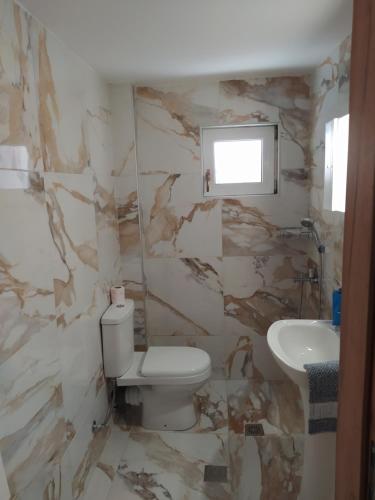 een badkamer met een wit toilet en een wastafel bij Εirene room in Chalkida