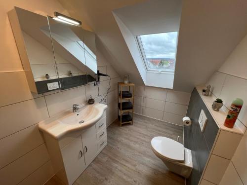 a bathroom with a sink and a toilet and a window at Ferienwohnung Löwen in Wabern