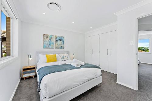 Un dormitorio blanco con una cama grande y una ventana en AirCabin - Norwest - Luxury Lovely - 4 Beds House, en Baulkham Hills