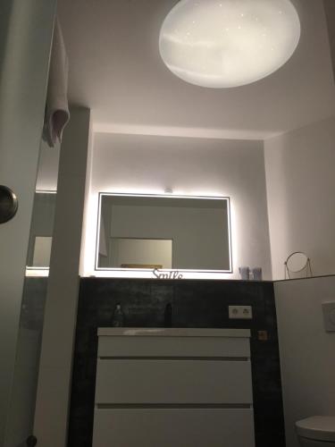 een badkamer met een wastafel en een spiegel aan de muur bij Römerpark 2 Zi-Appartement in Lindau