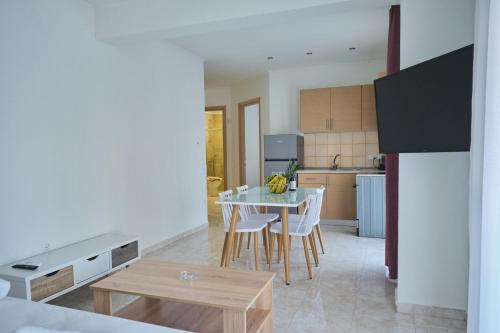 a kitchen and dining room with a table and chairs at BUTTERFLY SUITES by STELIOS in Keramotí