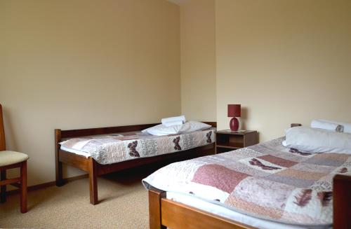 a room with two beds and a chair at Bajka in Krynica Zdrój