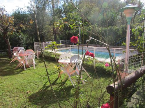 un patio con sillas y una piscina en Cabañas la Casa del Tata, en Potrero de los Funes