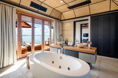 a bathroom with a tub and a view of the ocean at Lily Beach Resort and Spa - All Inclusive in Dhangethi