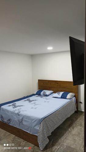 a bedroom with a bed and a flat screen tv at Casa víctoria in Bello